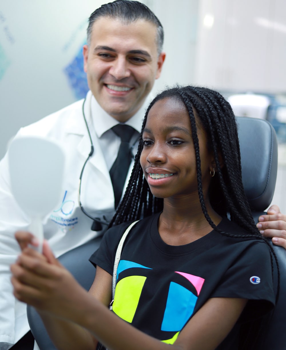 Orthodontist and patient looking at smile in the mirror