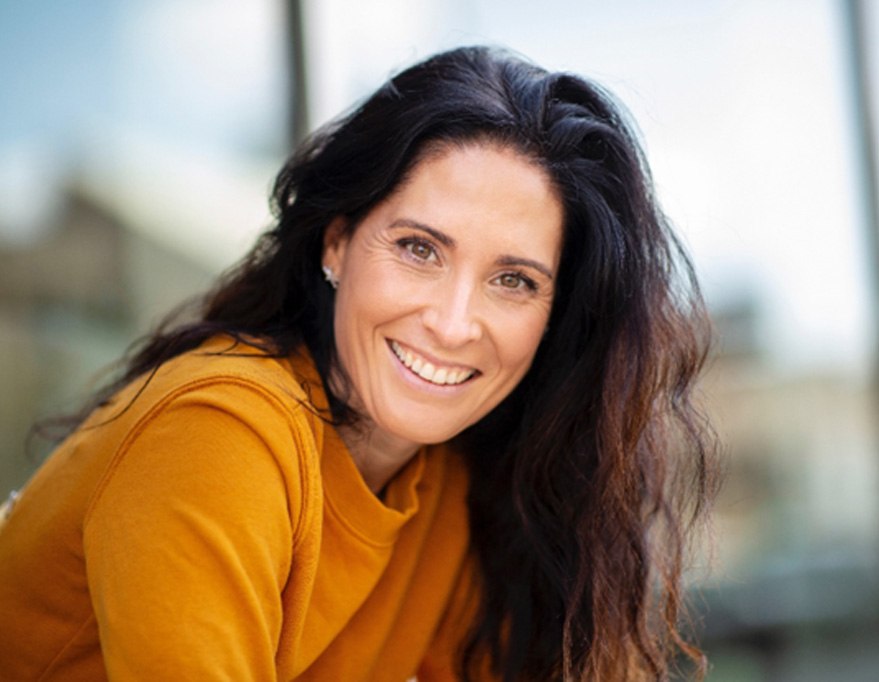 smiling lady sitting in front of a building