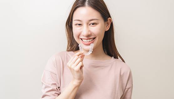 Happy woman holding Angel Aligner