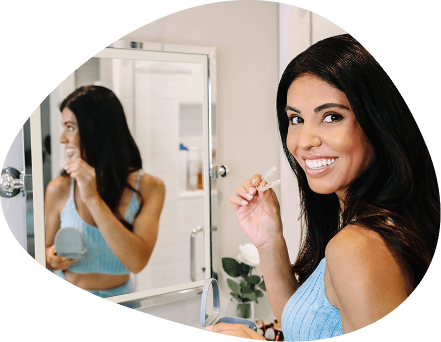Smiling woman placing clear aligners