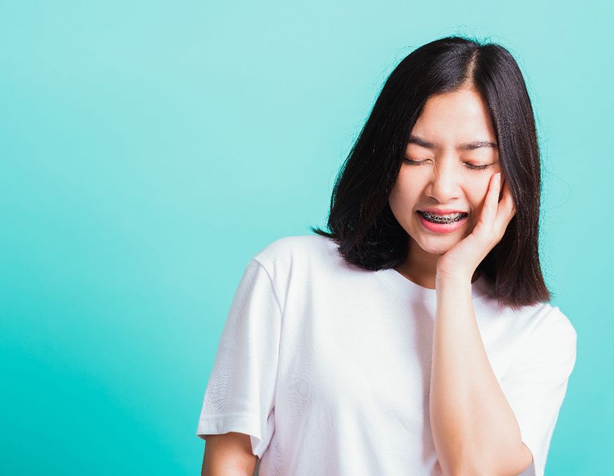Young woman should visit her Queens emergency orthodontist