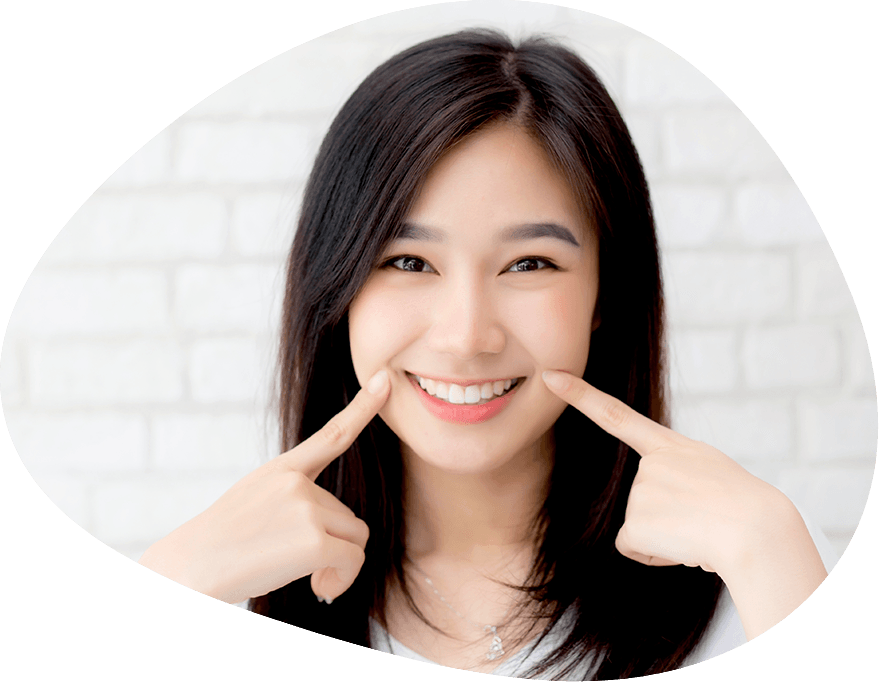 Woman with hidden braces pointing to smile