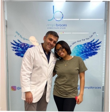 Orthodontist and young woman smiling together in Queens orthodontist office
