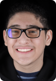 Young man grinning after seeing his orthodontist in Queens