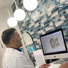 Orthodontist looking at digital bite impressions on computer screen in Queens