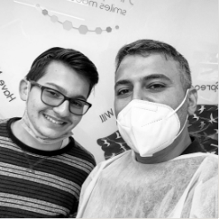 Orthodontist and patient smiling together in treatment room