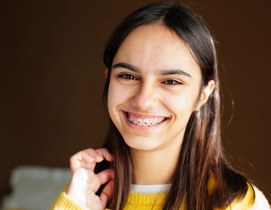 a teen with braces smiling