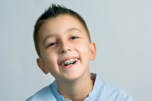 Young boy smiling with braces in Queens