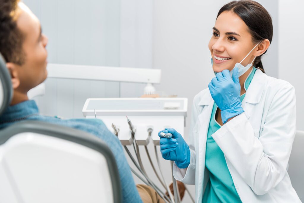 Orthodontist smiling at patient in treatment chair